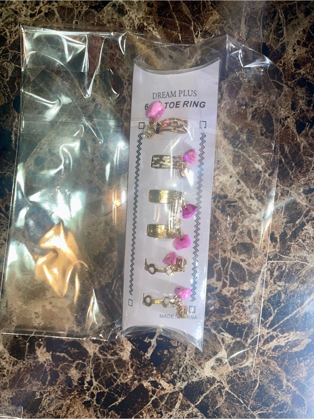 Fashion Jewelry Gold Tone Toe Ring Set with Pink Charms and other jewelry.